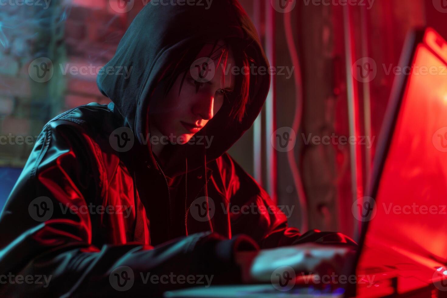 Hacker in hood hacking at computer in dark room. Computer criminal uses malware to hack devices photo