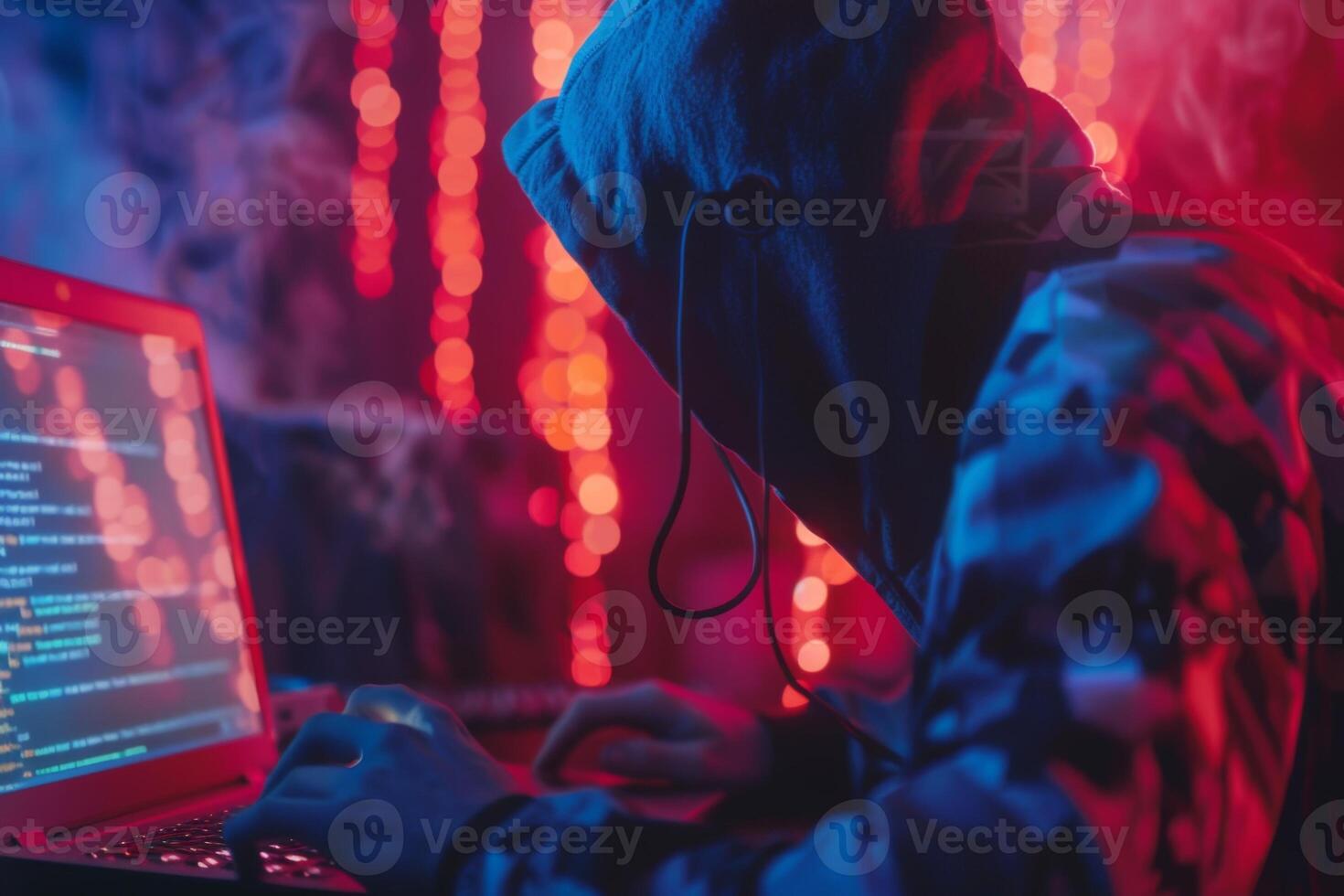 Hacker in hood hacking at computer in dark room. Computer criminal uses malware to hack devices photo