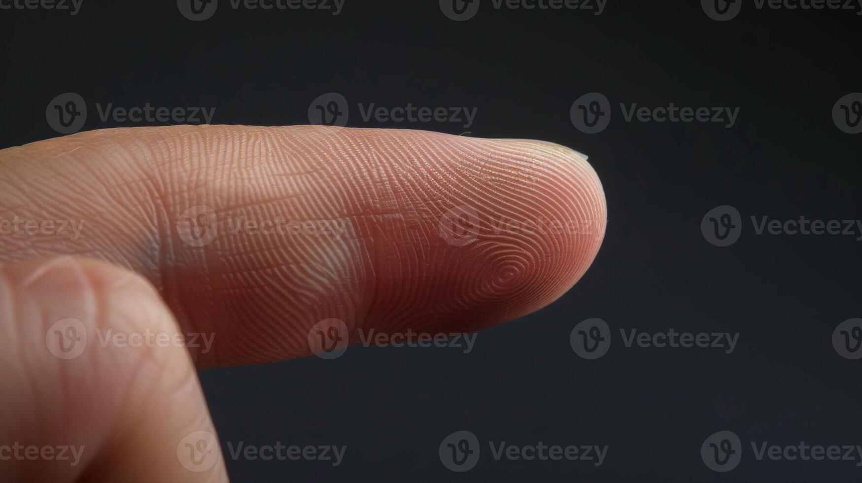 Finger with friction ridges on dark background, macro view photo