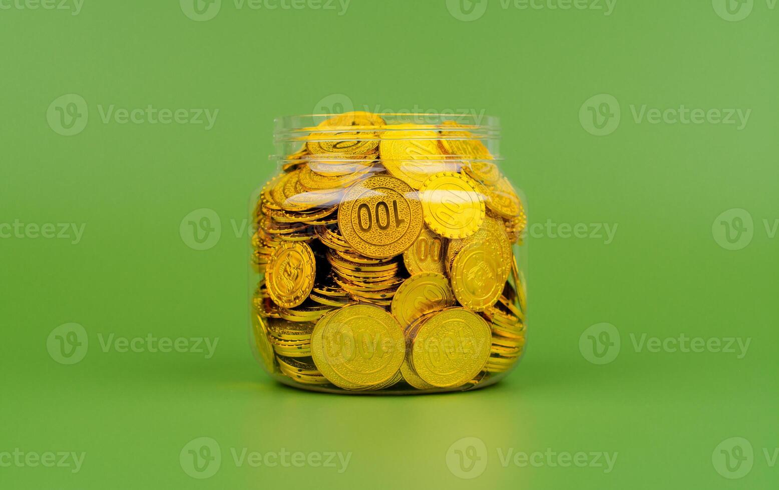 Saving gold coins in a glass jar, concept of saving and investing in gold. High value gold market photo