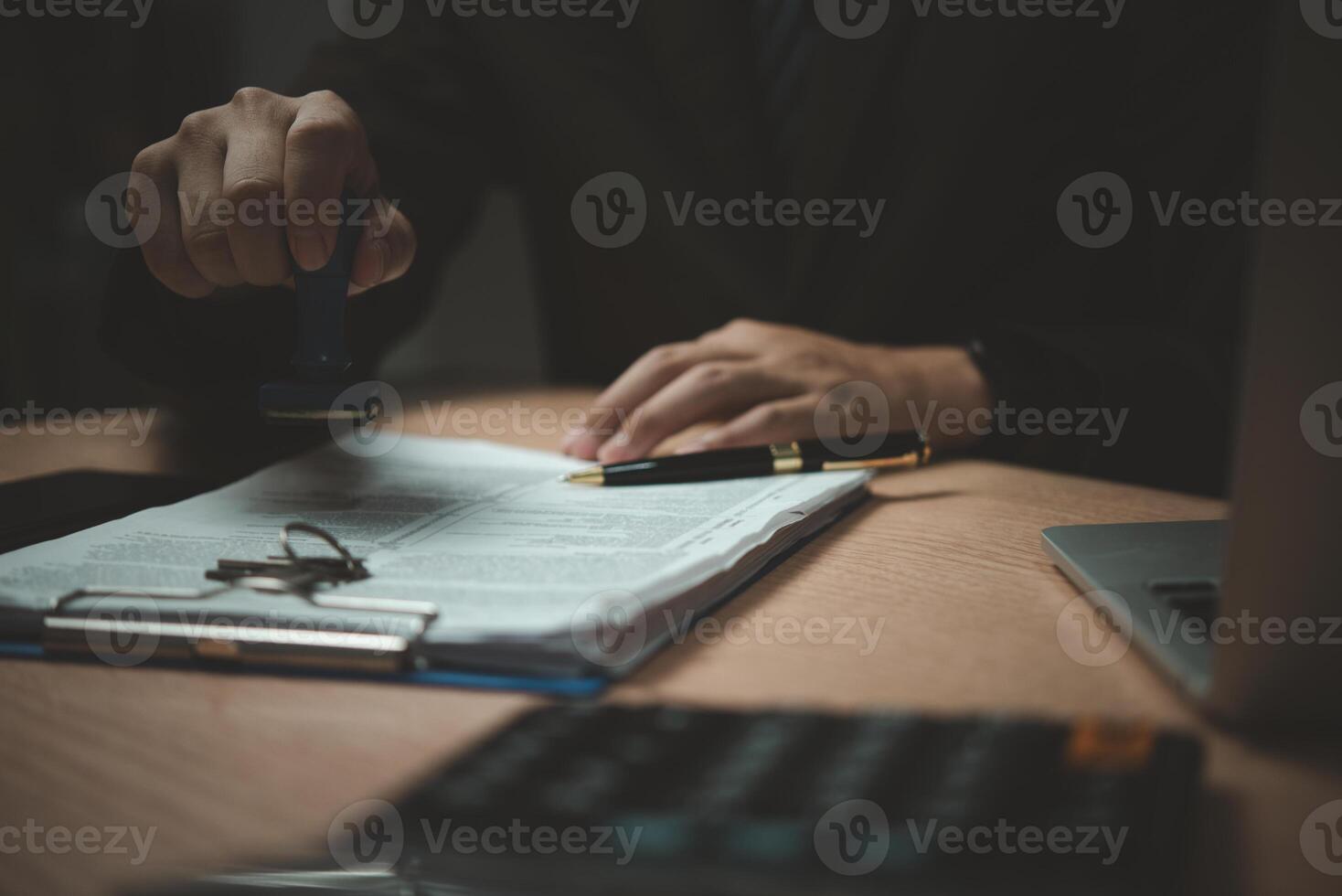 A man is signing a document with a stamp photo