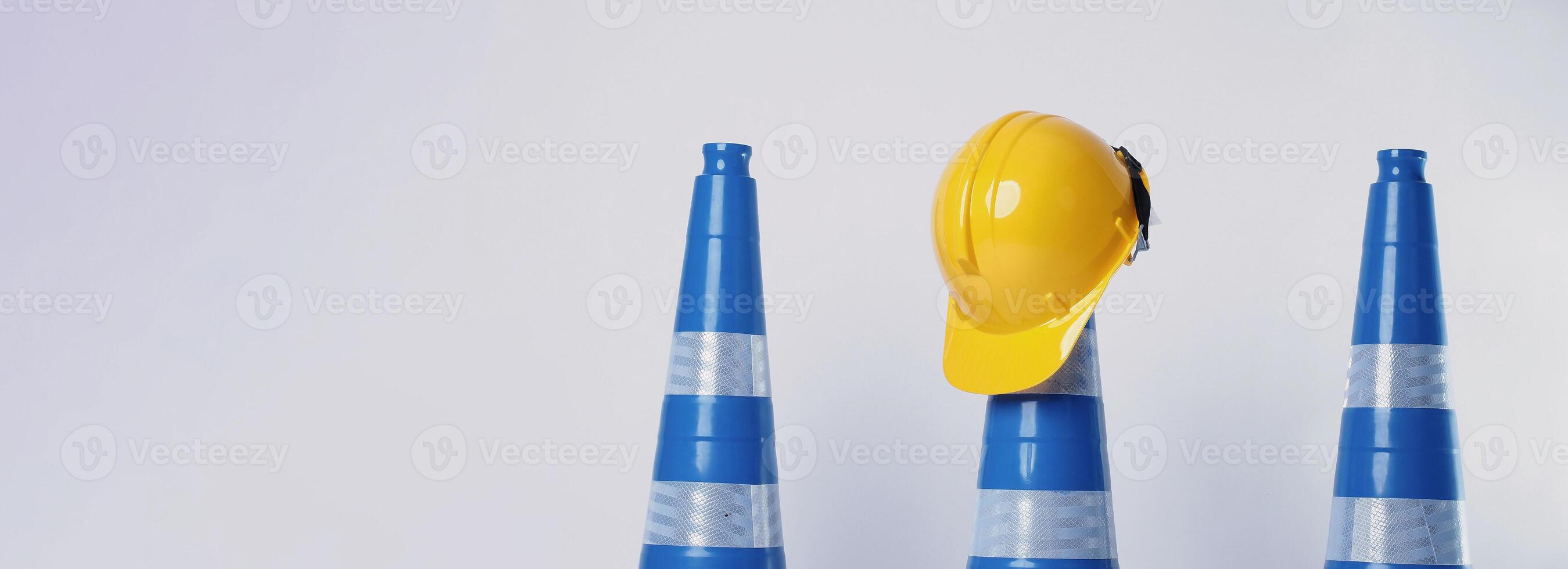 Realistic blue traffic cones and yellow safety helmet isolated on white background. photo