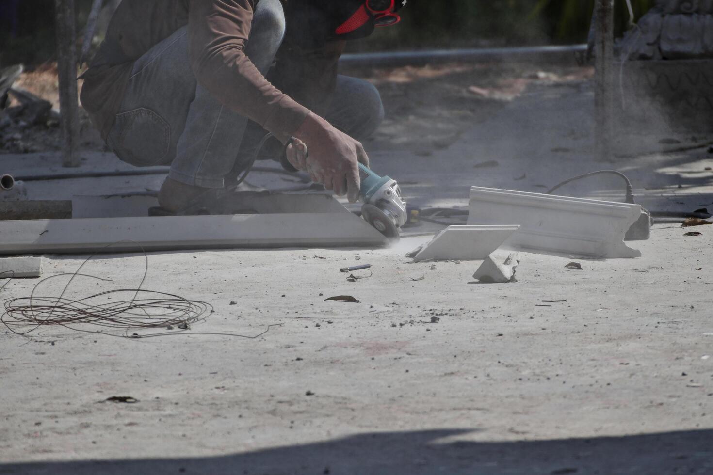 A worker is using a tool to cut cement rods. causing dust to permeate concept of safety at work photo