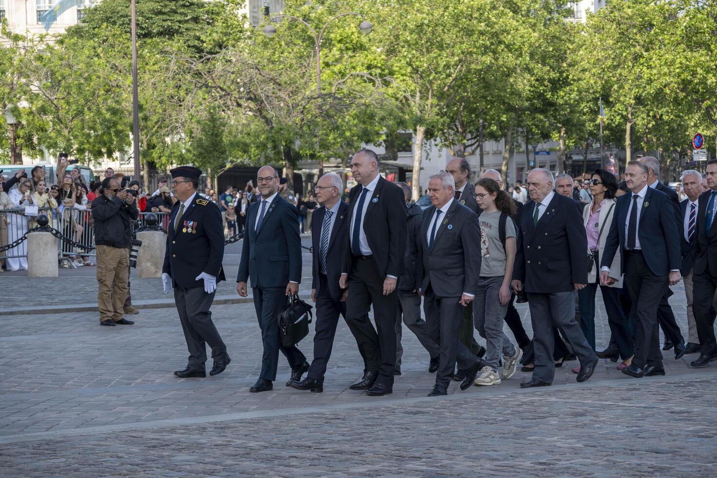 French war veterans wearing uniforms and representatives at a military ceremony under the Arc de Triomphe photo
