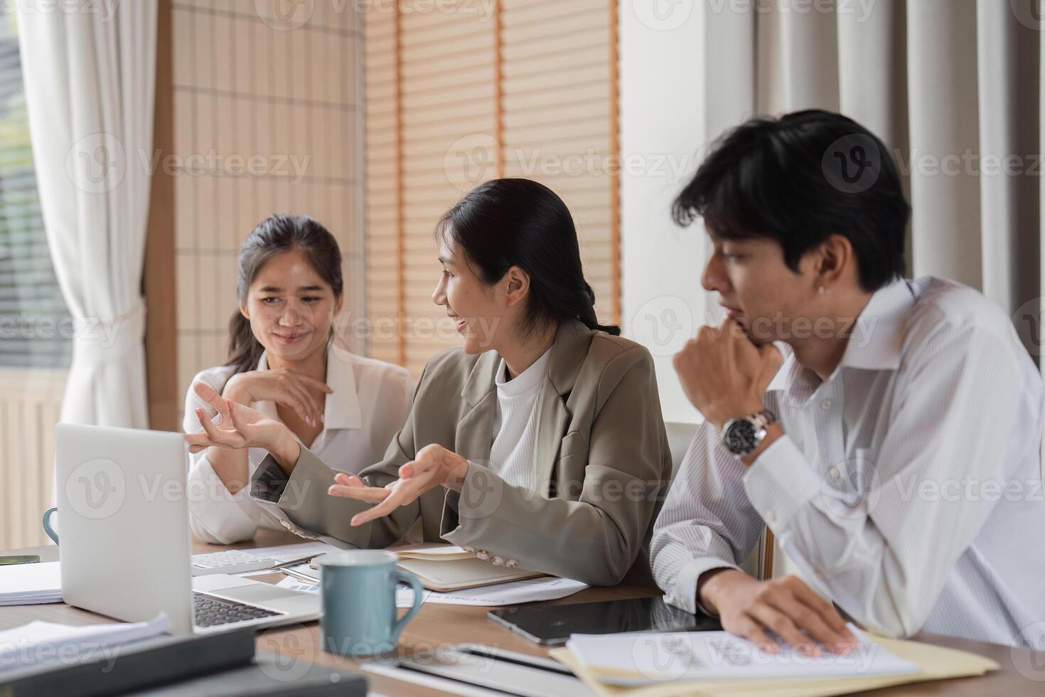 Business Team Engaged in Discussion and Consultation in Modern Office Setting with Laptop and Documents photo