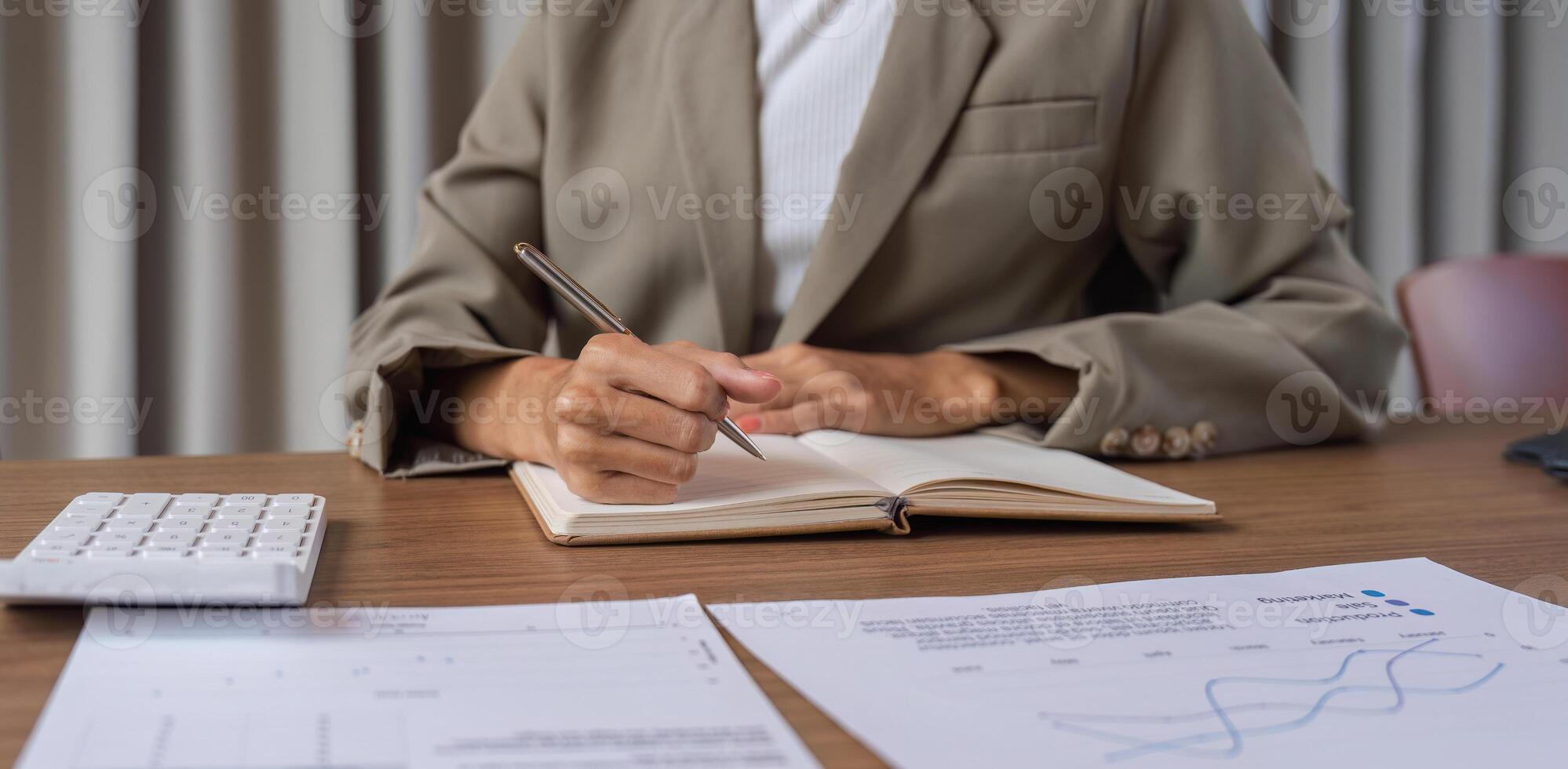 Professional Business Team Taking Meeting Notes During a Collaborative Office Meeting with Financial Documents and Calculator photo
