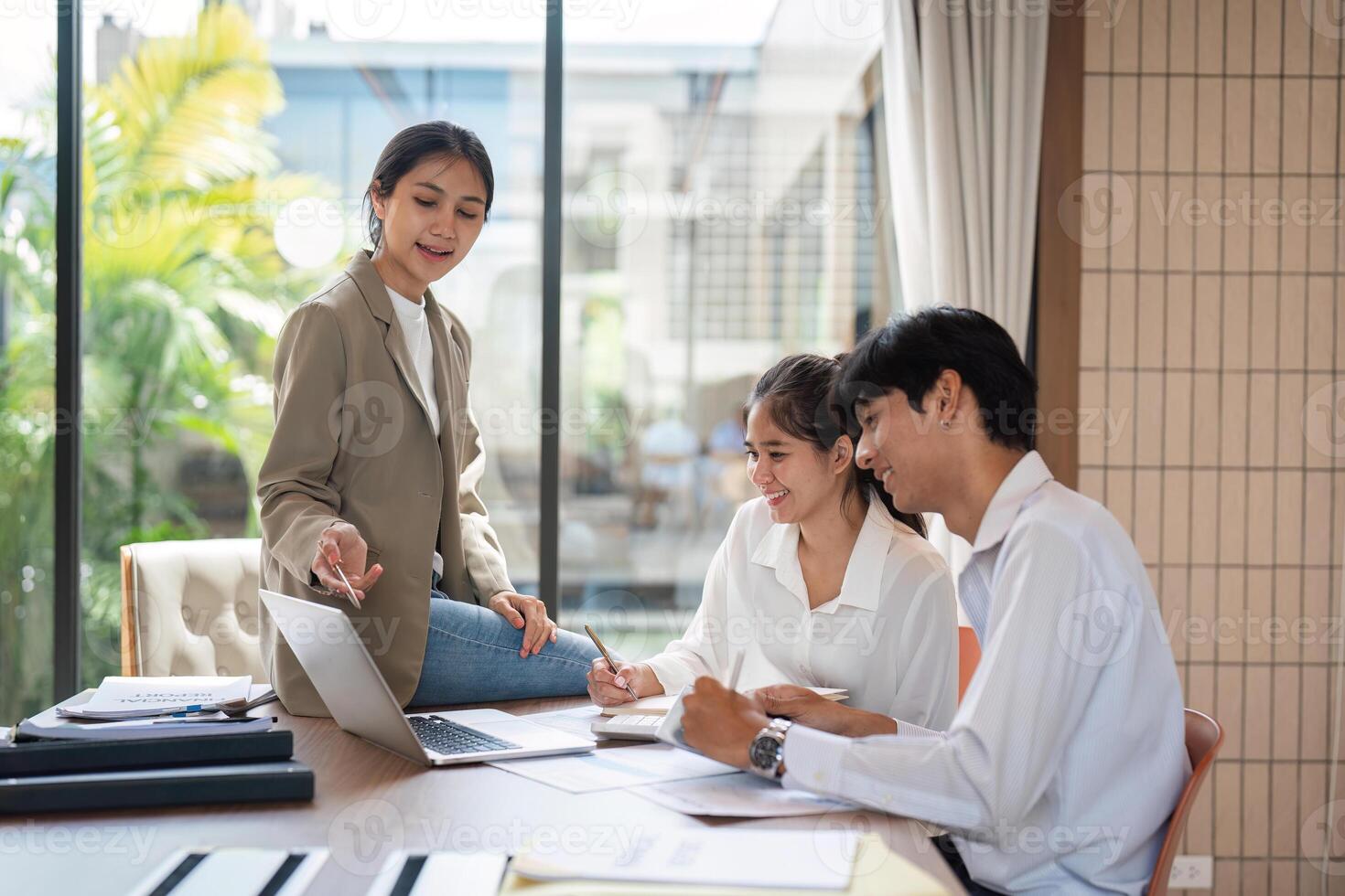 Business Team Collaborating in Modern Office Environment with Natural Light and Greenery photo