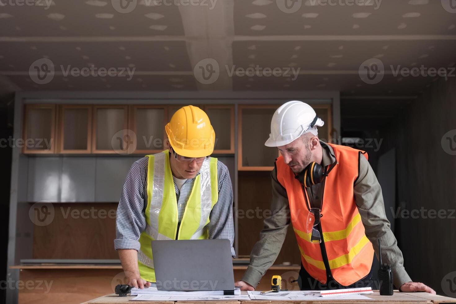 Engineering Team Collaborates on Work Plan at Construction Site with Safety Gear and Blueprints photo