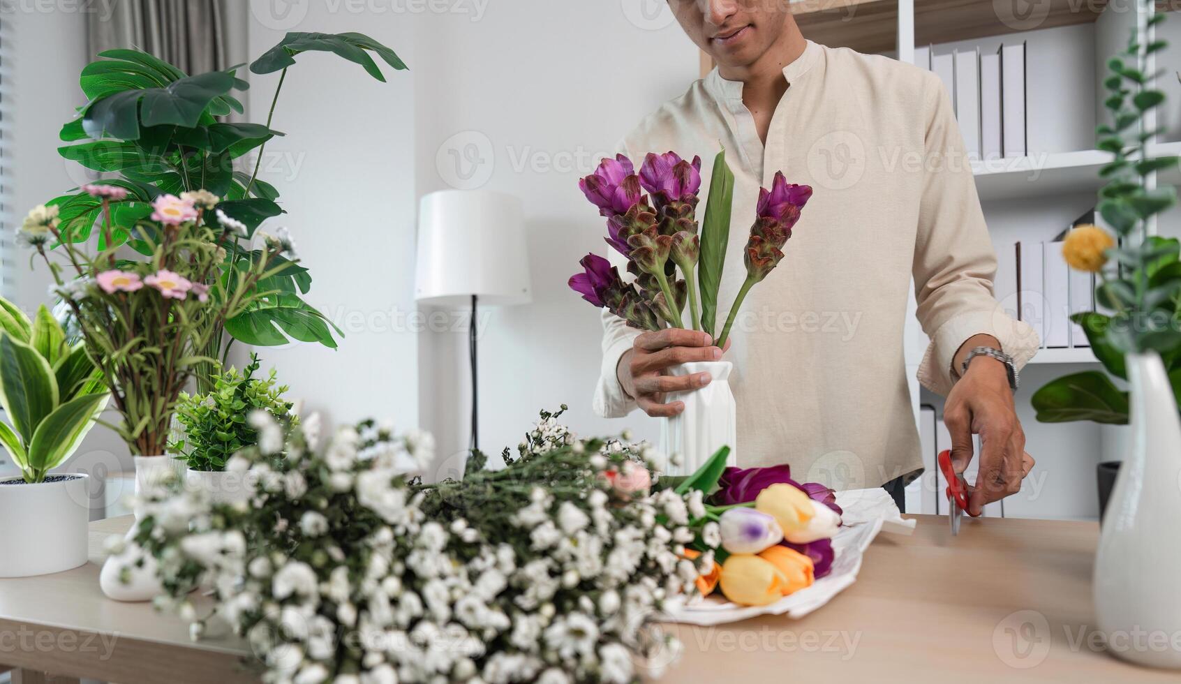 Young Man Relaxing in His Modern Room with Bookshelves and Flowers, Enjoying Leisure Time at Home photo