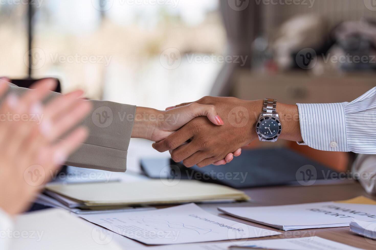 Businessmen Shaking Hands Sealing a Deal in a Modern Office Setting with Documents on the Table photo