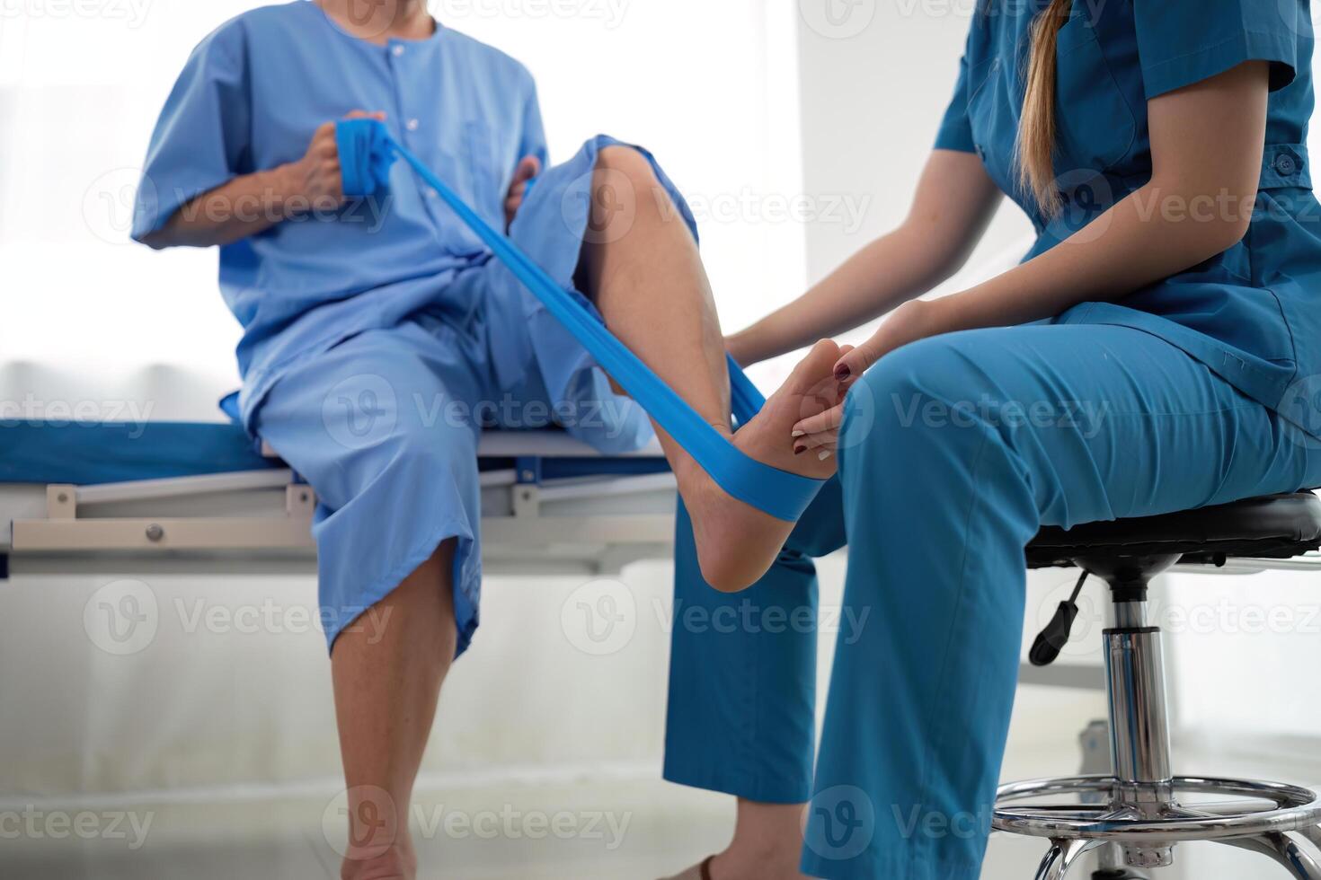a woman in a blue uniform helps a man in a hospital bed photo