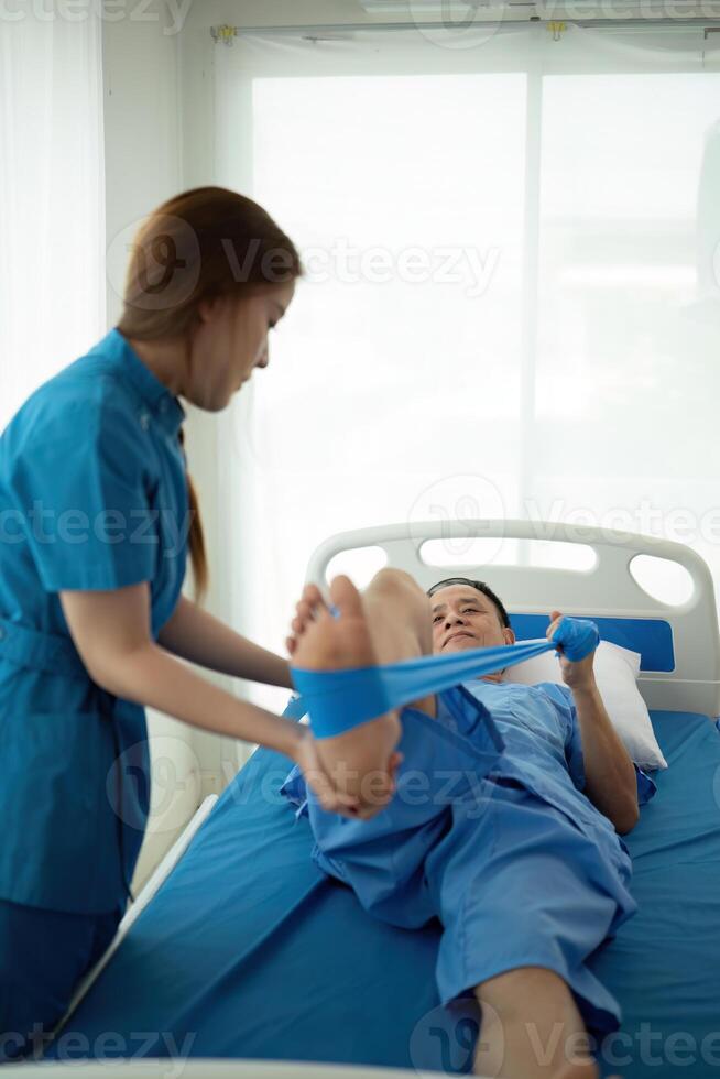 a woman in a blue uniform helps a man in a hospital bed photo