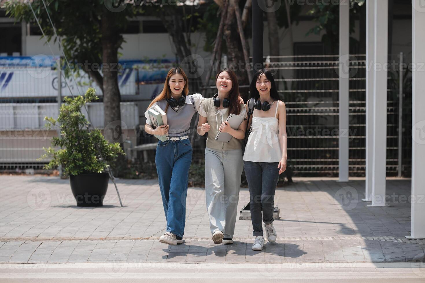 Group of happy students walking along the corridor at college photo