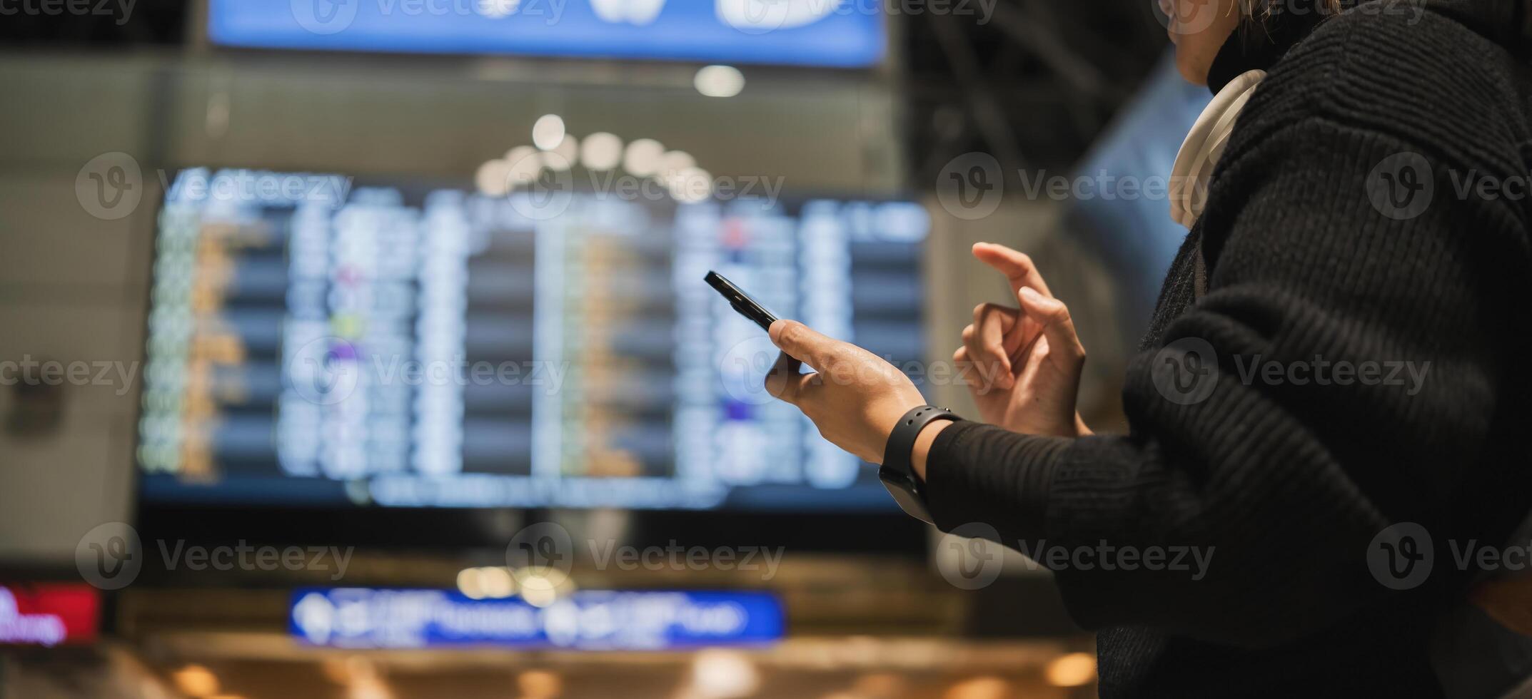 Close-up of woman checking phone at airport terminal, Concept of travel and technology photo