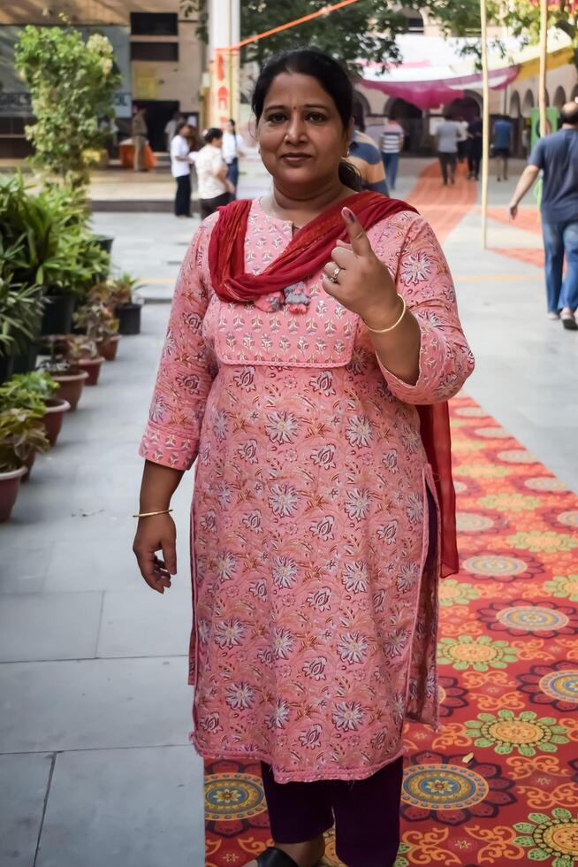 New Delhi, India - May 25 2024 - Unidentified people showing their ink-marked fingers after casting votes in front of polling booth of east Delhi area for general Lok Sabha Elections 2024 photo