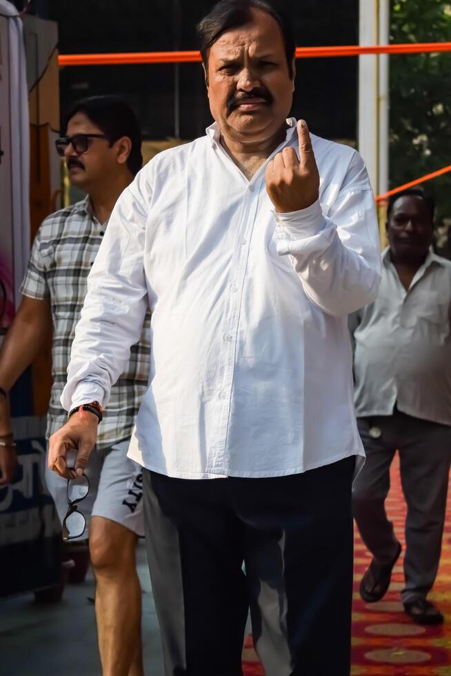 New Delhi, India - May 25 2024 - Unidentified people showing their ink-marked fingers after casting votes in front of polling booth of east Delhi area for general Lok Sabha Elections 2024 photo