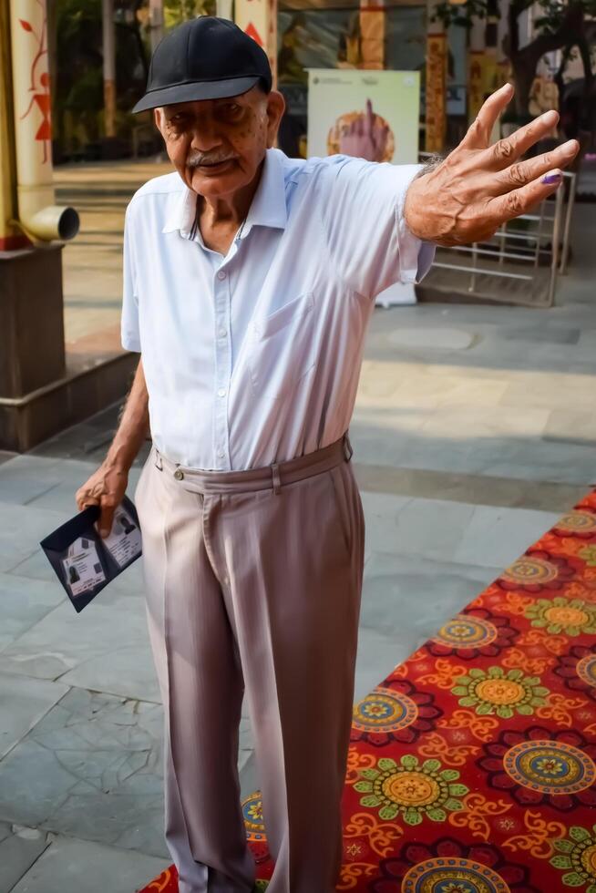 New Delhi, India - May 25 2024 - Unidentified people showing their ink-marked fingers after casting votes in front of polling booth of east Delhi area for general Lok Sabha Elections 2024 photo