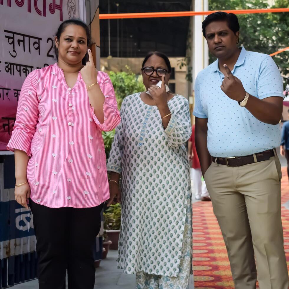 New Delhi, India - May 25 2024 - Unidentified people showing their ink-marked fingers after casting votes in front of polling booth of east Delhi area for general Lok Sabha Elections 2024 photo