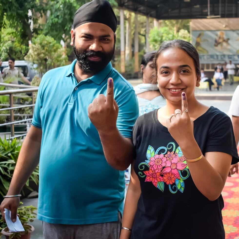 New Delhi, India - May 25 2024 - Unidentified people showing their ink-marked fingers after casting votes in front of polling booth of east Delhi area for general Lok Sabha Elections 2024 photo