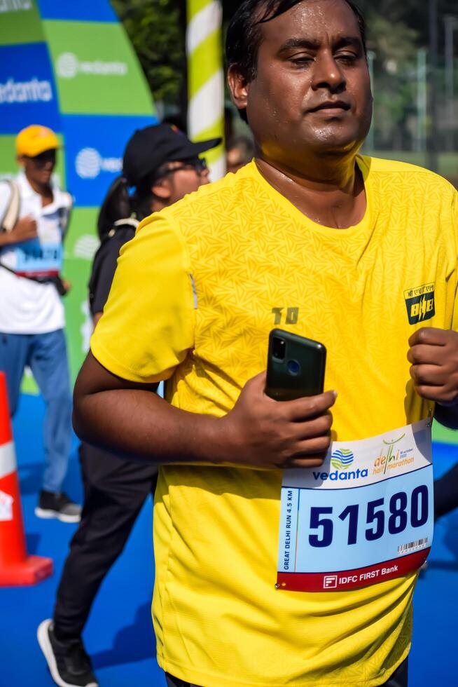 New Delhi, India - June 30 2024 - Vedanta Delhi Half Marathon race after covid in which marathon participants about to cross the finish line, Delhi Half Marathon 2023 photo