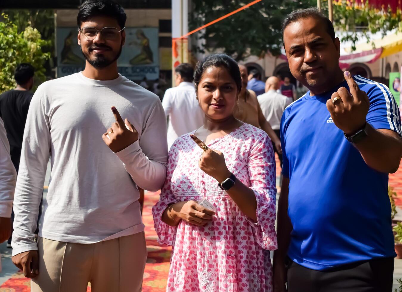 New Delhi, India - May 25 2024 - Unidentified people showing their ink-marked fingers after casting votes in front of polling booth of east Delhi area for general Lok Sabha Elections 2024 photo