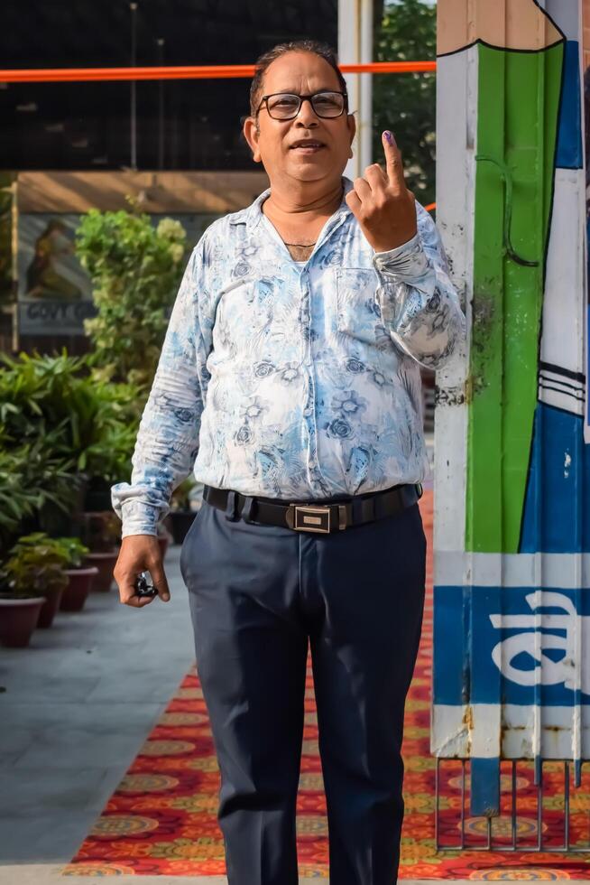 New Delhi, India - May 25 2024 - Unidentified people showing their ink-marked fingers after casting votes in front of polling booth of east Delhi area for general Lok Sabha Elections 2024 photo