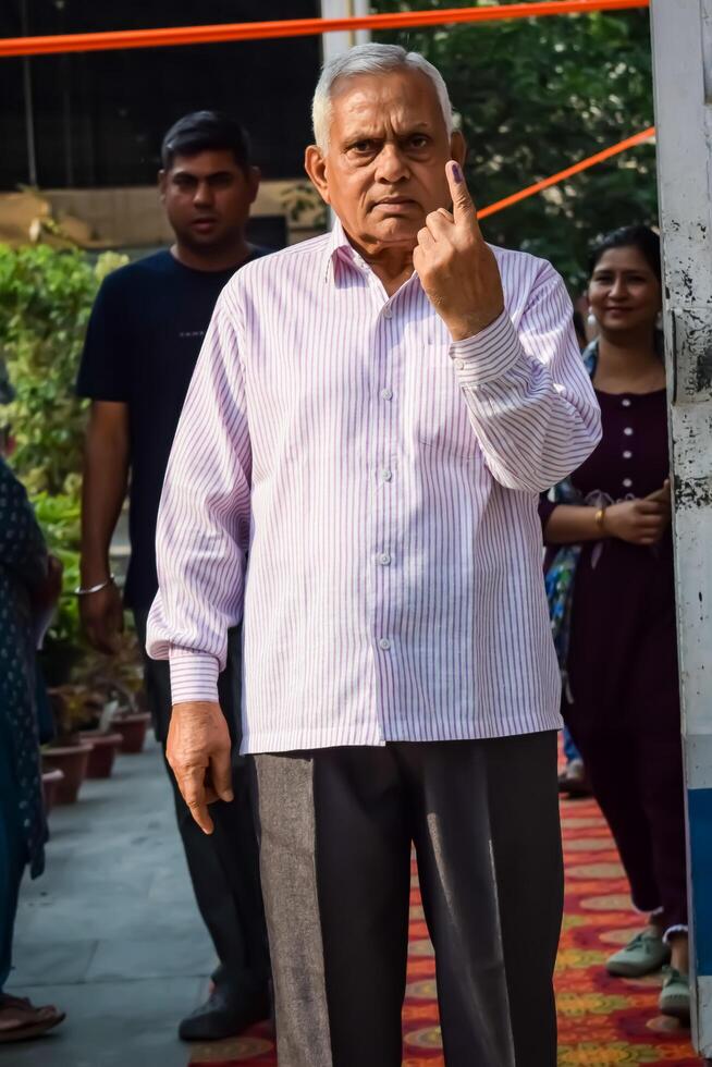 New Delhi, India - May 25 2024 - Unidentified people showing their ink-marked fingers after casting votes in front of polling booth of east Delhi area for general Lok Sabha Elections 2024 photo
