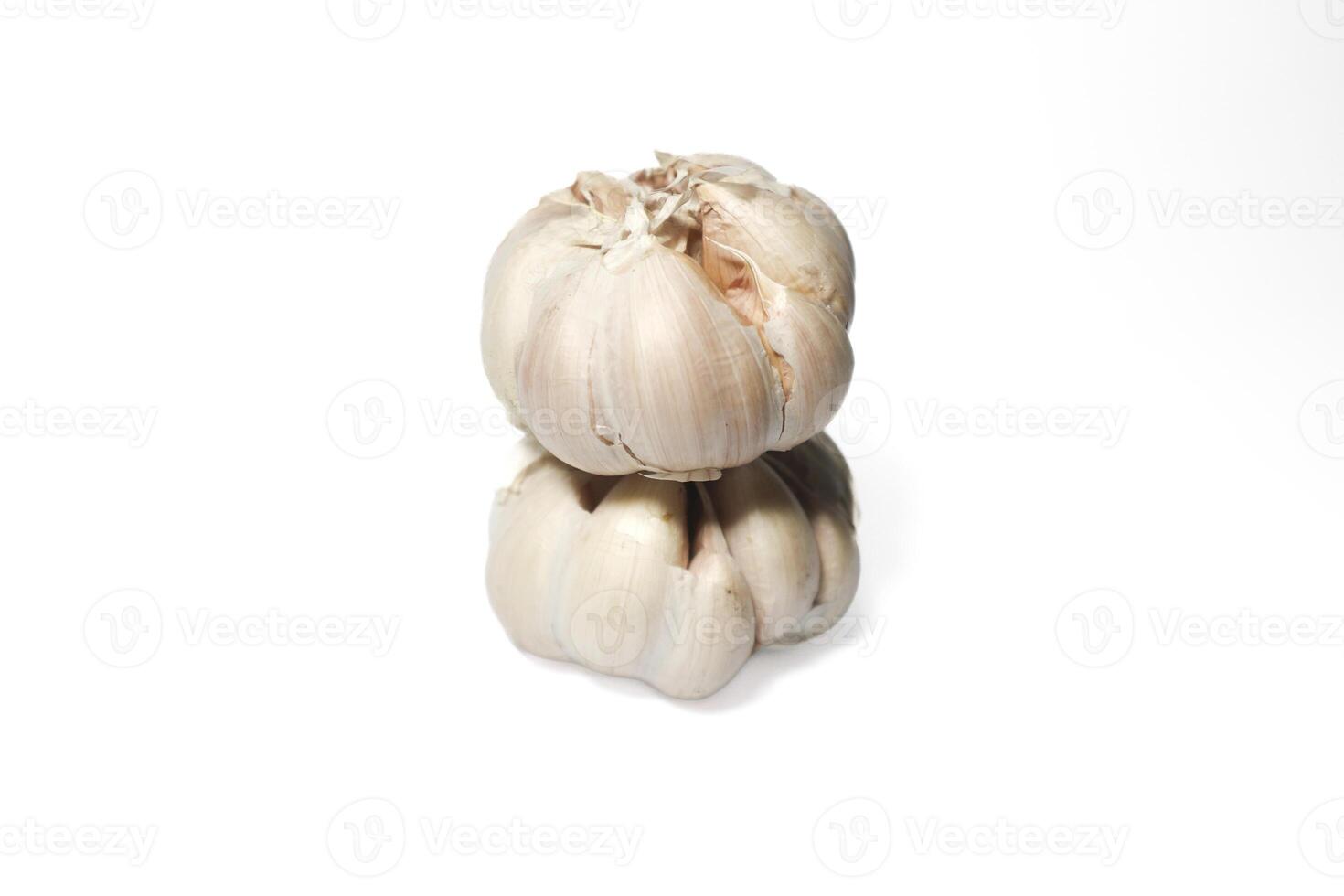 two garlic cloves stacked on top of each other. isolated background. white background. photo