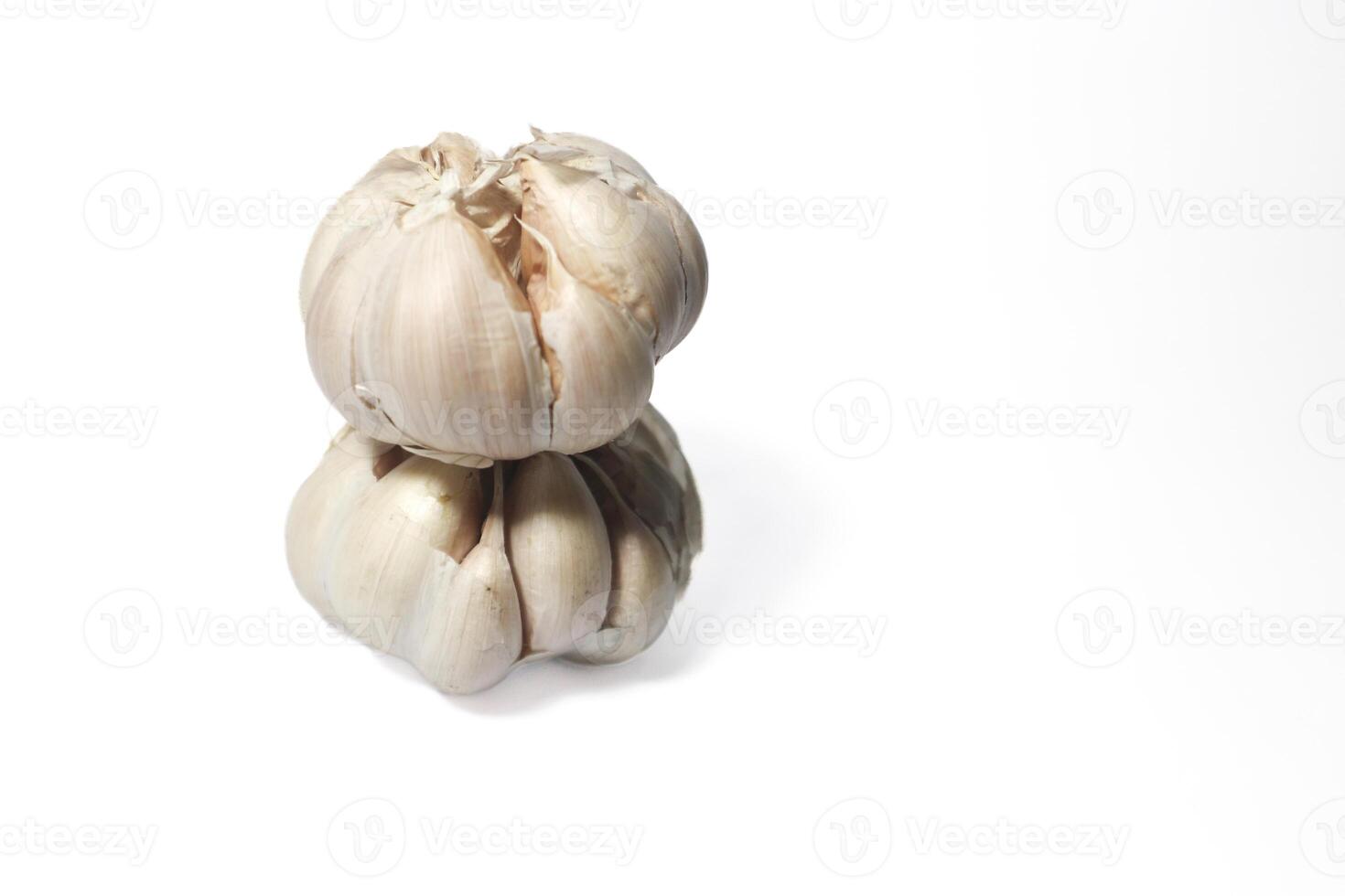 two garlic cloves stacked on top of each other. isolated background. white background. photo