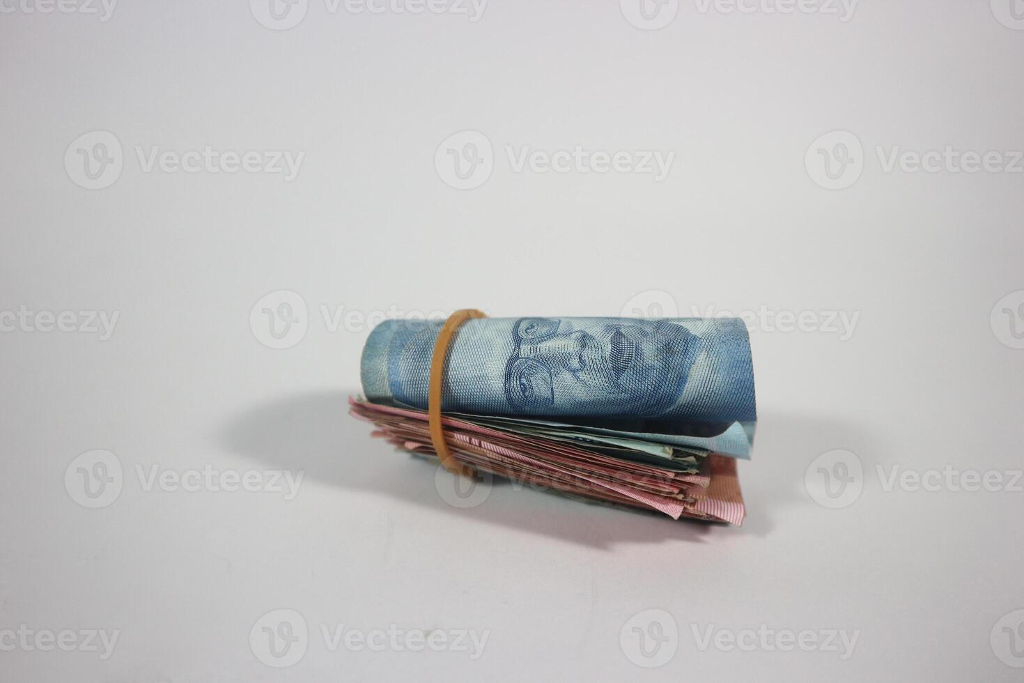 indonesian rupiah banknotes rolled into a tube and tied with a rubber band. Money roll isolated on a white background photo