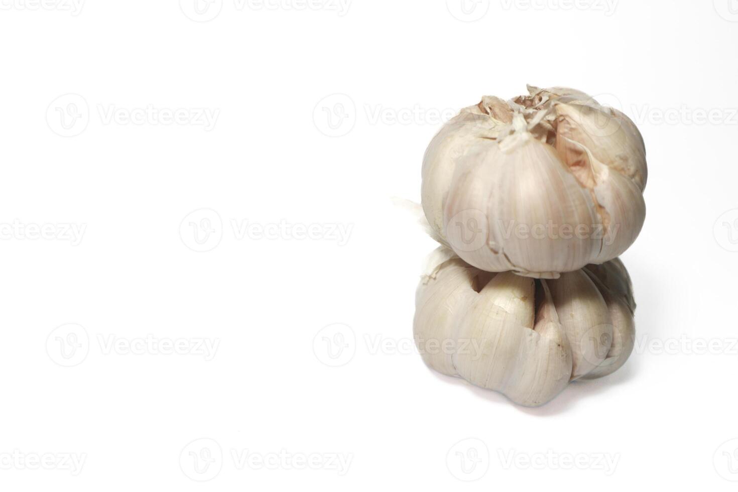 two garlic cloves stacked on top of each other. isolated background. white background. photo