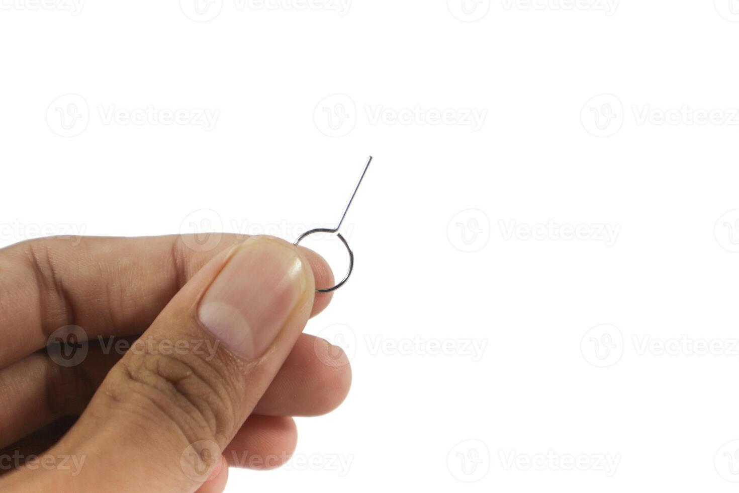Hand Holding a SIM card ejector pin isolated on white background. photo