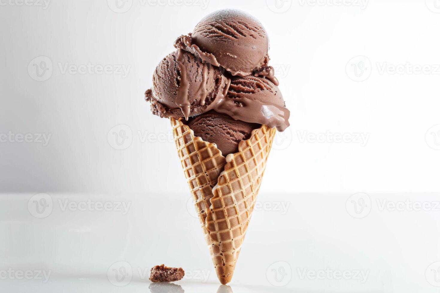 A chocolate ice cream cone is placed on a white table photo