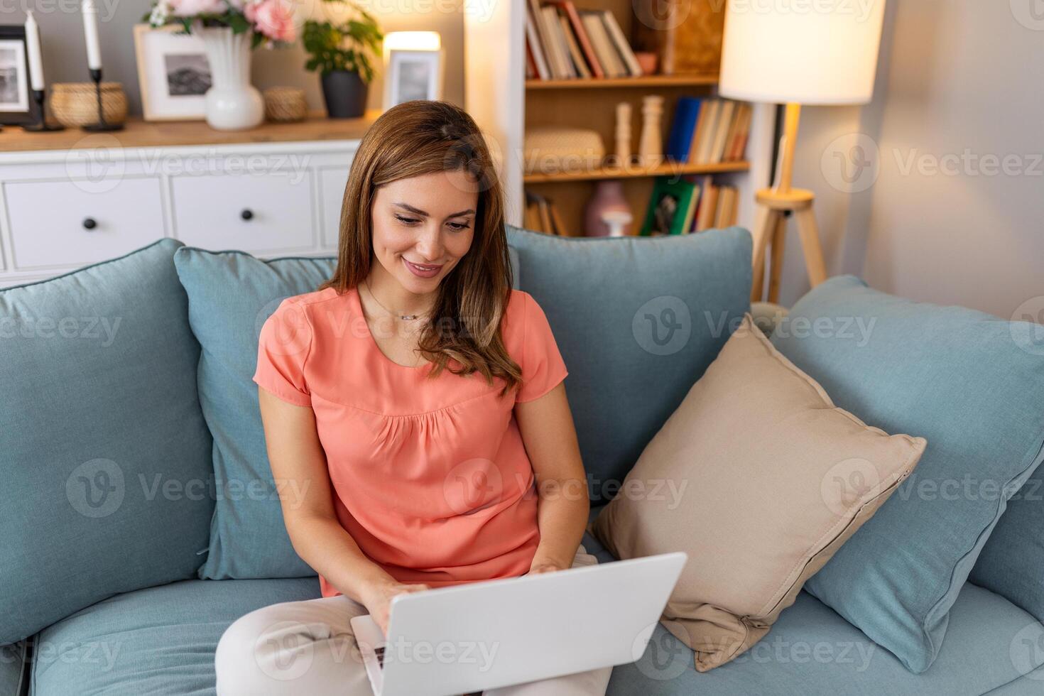 Beautiful woman freelancer noting information for planning project doing remote job via laptop computer. woman laughing while reading email on modern laptop device . photo