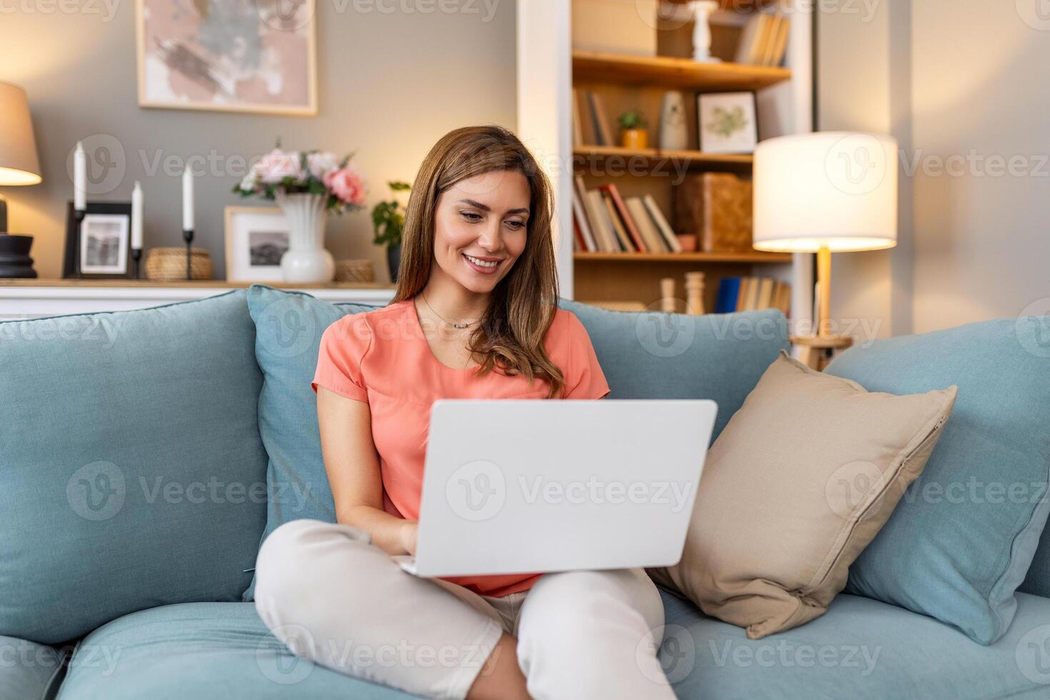 Beautiful woman freelancer noting information for planning project doing remote job via laptop computer. woman laughing while reading email on modern laptop device . photo