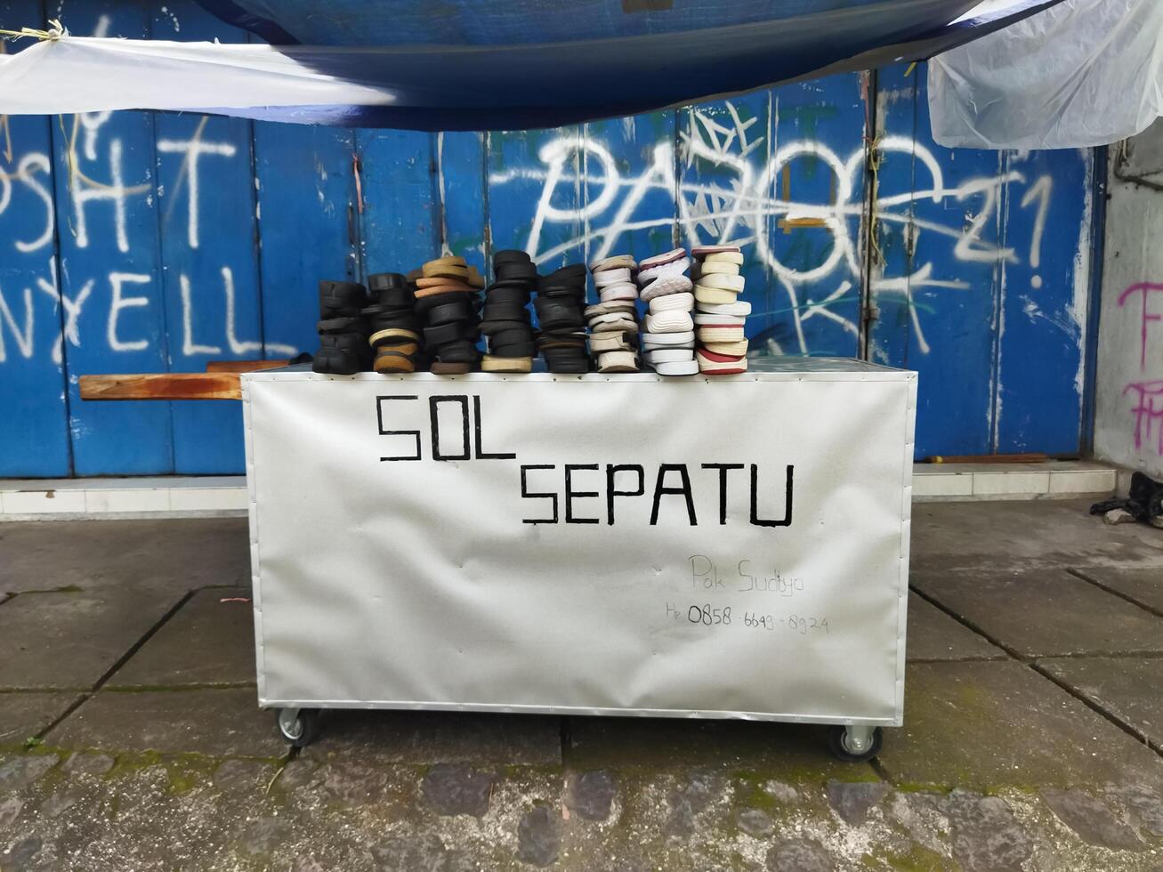 Bekonang, Sukoharjo, March 16, 2023. Gerobak tukang sol sepatu. Tailor damaged shoes so they can be used again. Shoe tailor. photo