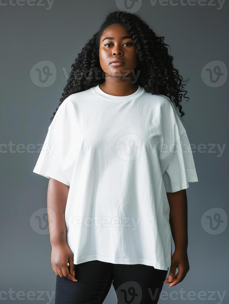 A beautiful woman wearing a plain white oversized tshirt and black jeans a grey background photo