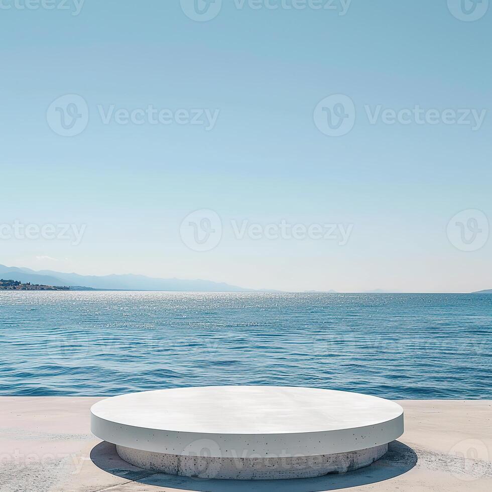 A round podium on the beach, surrounded by sand and sea in light beige tones photo
