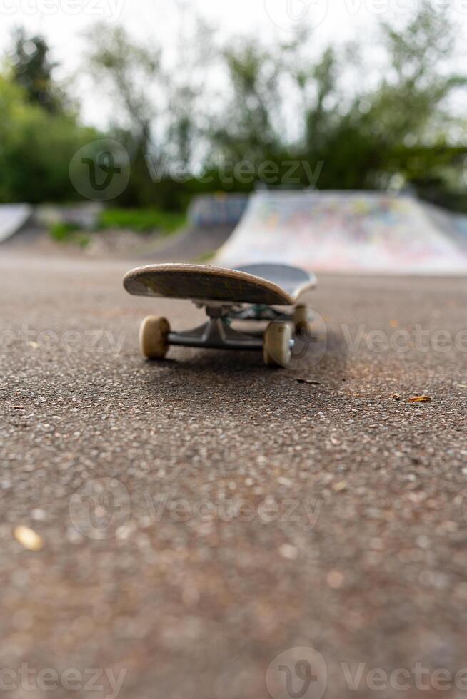 Skateboard Focus Style Life Concept. The skateboard is on the asphalt, the vertical photo is in soft focus.