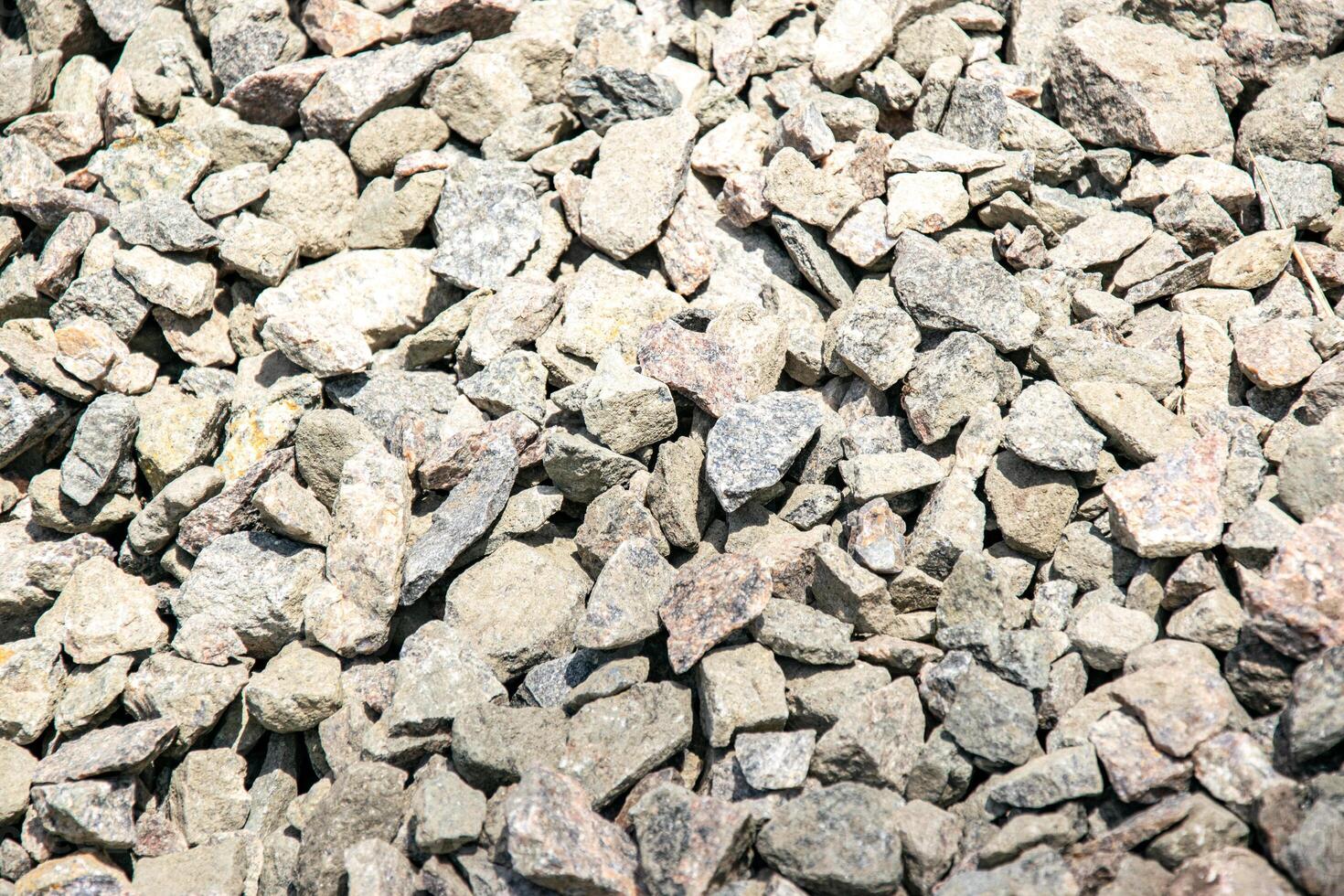 Close-up image of various sizes of grey and pink gravel stones photo