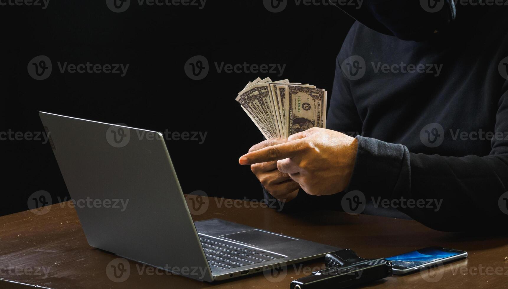 Hacker spy man one person black hoodie sitting hand holding credit card look computer laptop used login password attack security data digital internet network system night dark background copy space photo