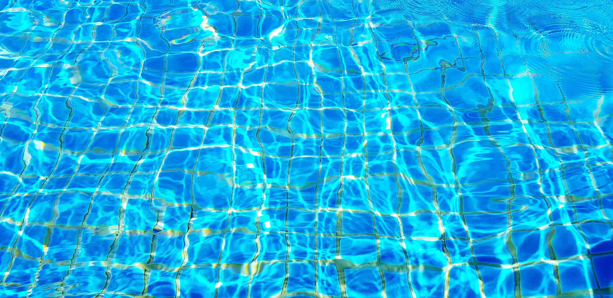 Wave or ripple water in swimming pool with sunlight reflection for background. Art or Abstract and Wallpaper concept. photo