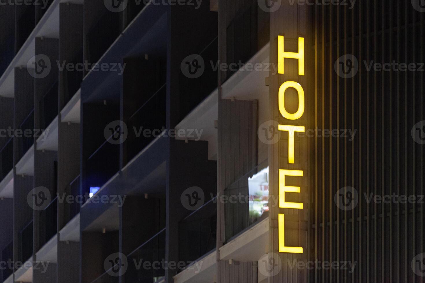 Illuminated yellow hotel sign by night photo