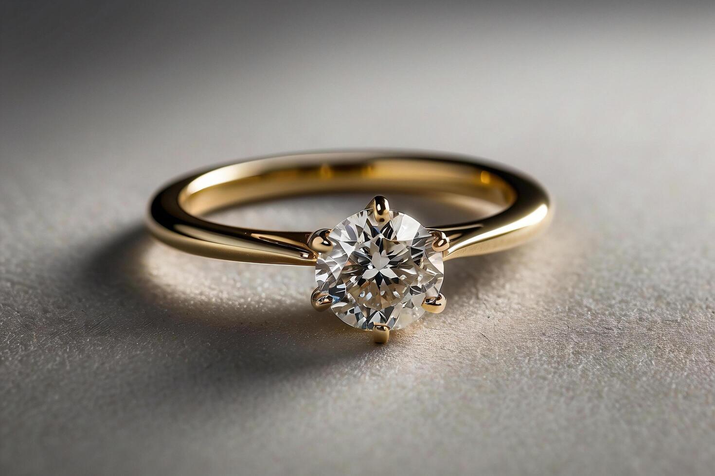 an elegant diamond engagement ring with a prominent solitaire, set on a slender gold band. The textured grey background adds a touch of sophistication photo