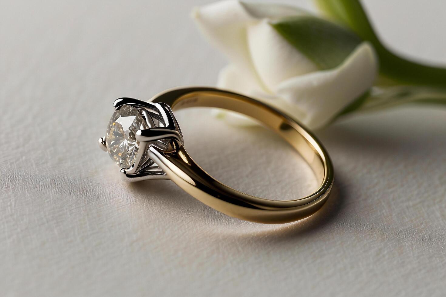 an elegant diamond engagement ring with a prominent solitaire, set on a slender gold band. The textured grey background adds a touch of sophistication photo
