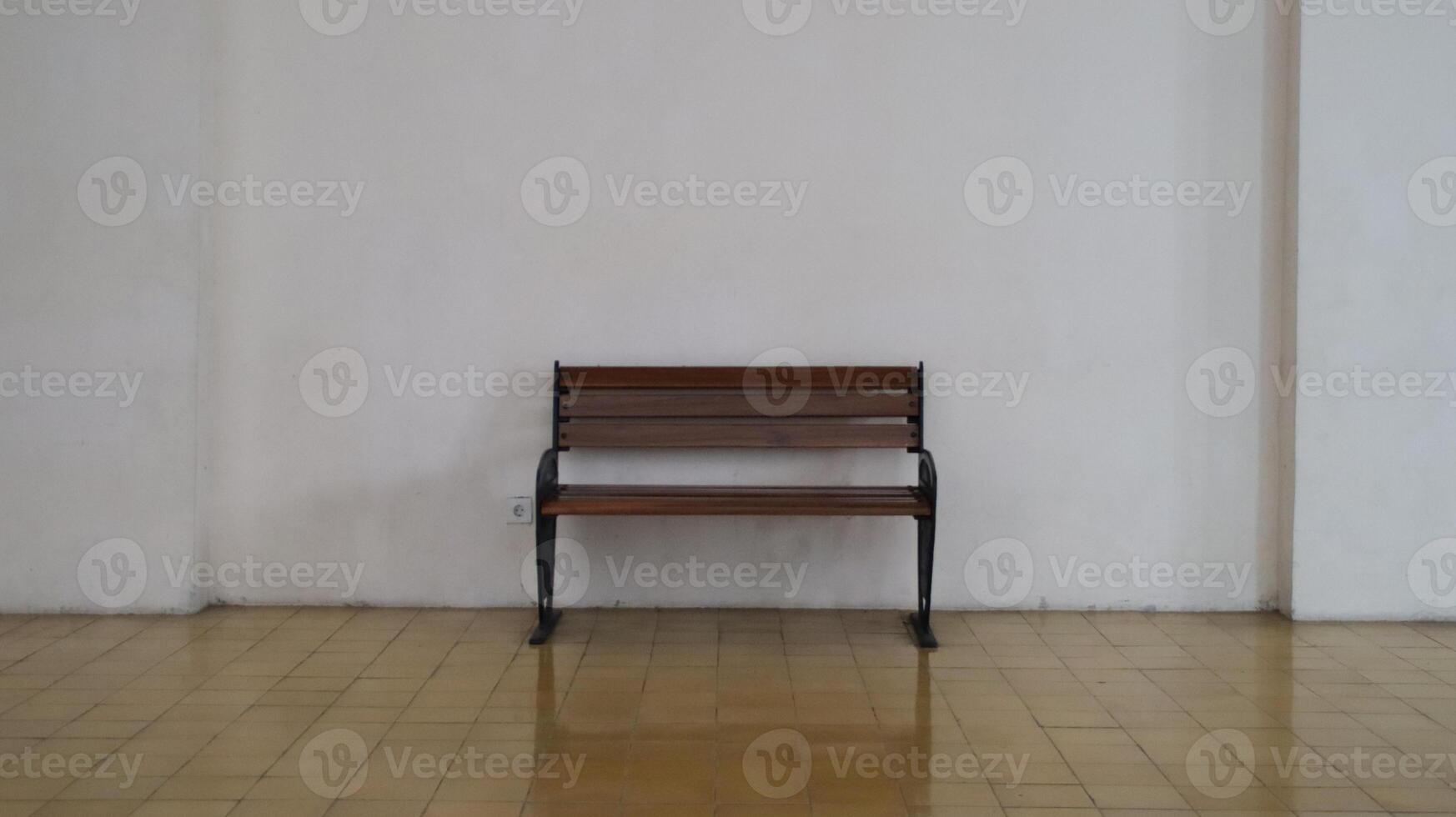 Simple Wooden Bench with Metal Frame in Minimalistic Indoor Setting Against White Wall with Tiled Floor photo