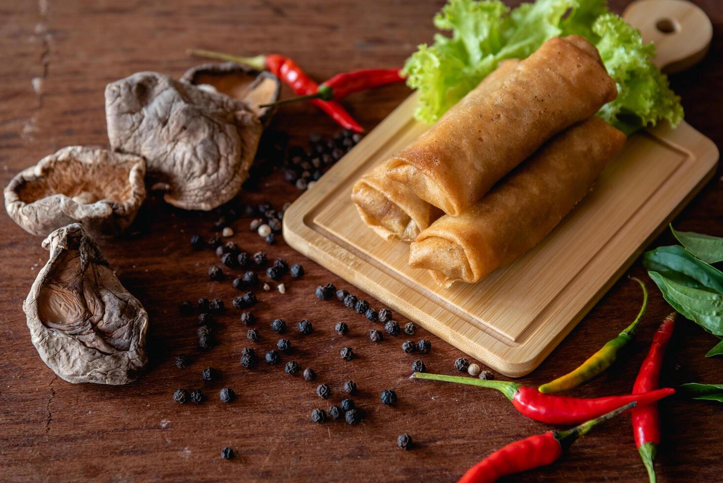 Chinese vegetable spring rolls with chopstick to dip in sauce on wooden background photo