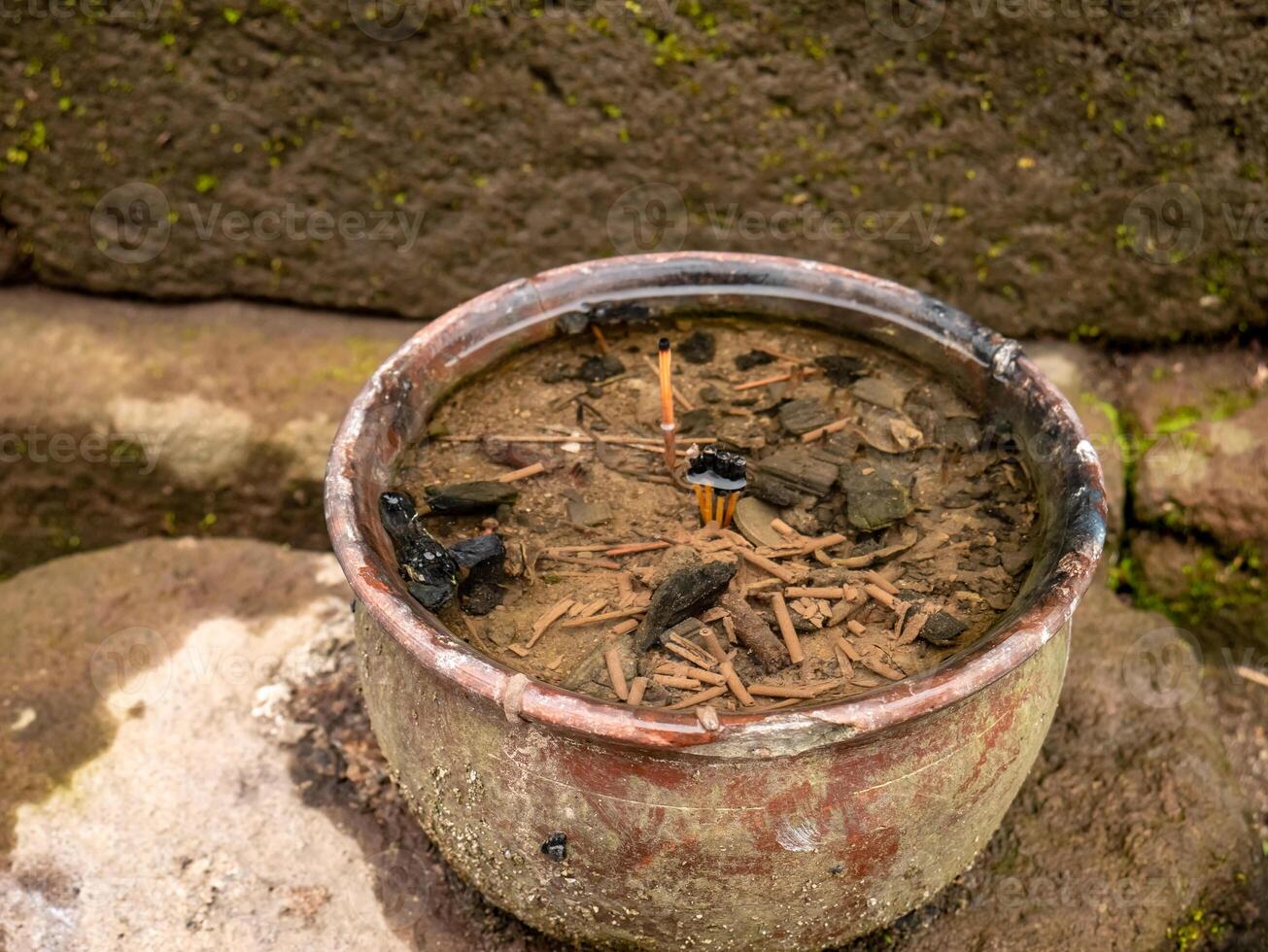 incense in a clay pot that is submerged in water because the weather often rains in the temple area in the mountains photo