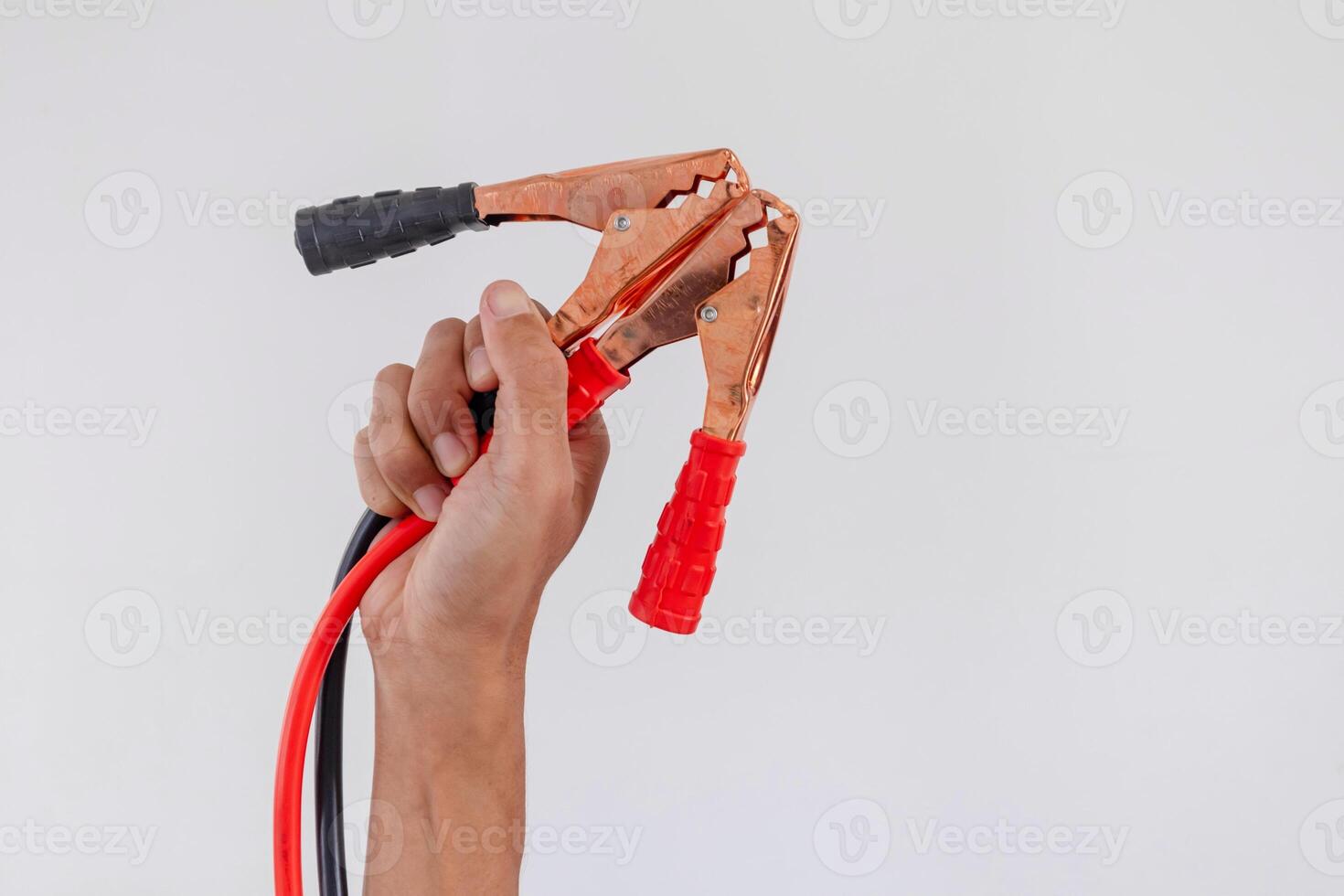 Hand holding red and black car battery jumper cable or booster cables on a white background photo