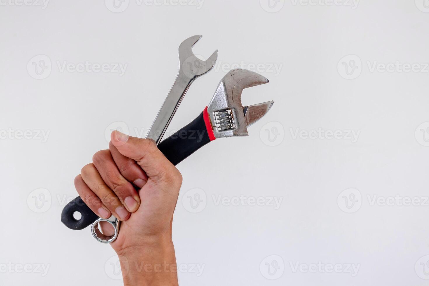Hand holding adjustable wrench and spanner on a white background photo